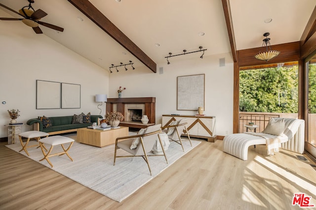 living room featuring beamed ceiling, ceiling fan, light hardwood / wood-style floors, and track lighting