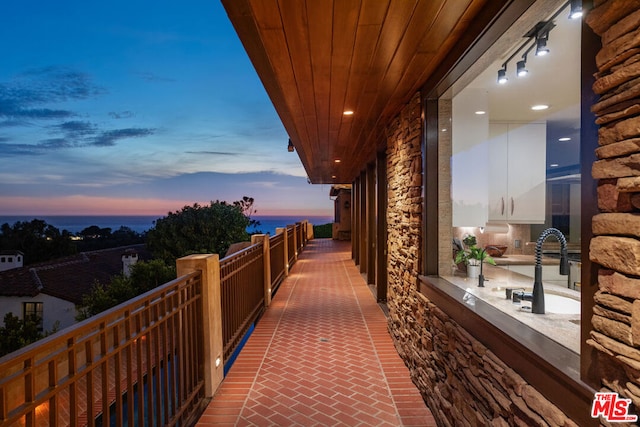 balcony at dusk featuring sink