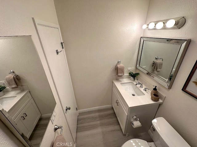 bathroom featuring hardwood / wood-style flooring, toilet, and vanity