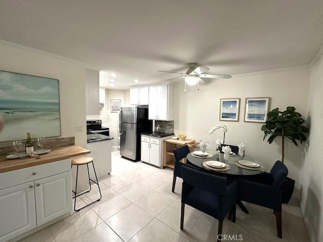 dining area with crown molding, light tile patterned floors, and ceiling fan