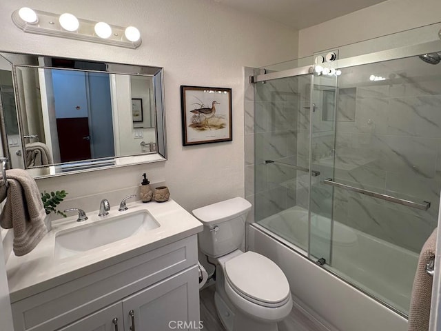 full bathroom featuring bath / shower combo with glass door, toilet, and vanity