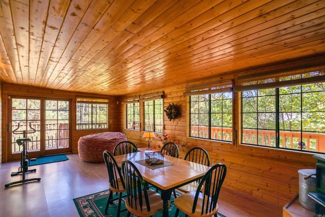 dining space featuring hardwood / wood-style flooring, wooden walls, and wooden ceiling