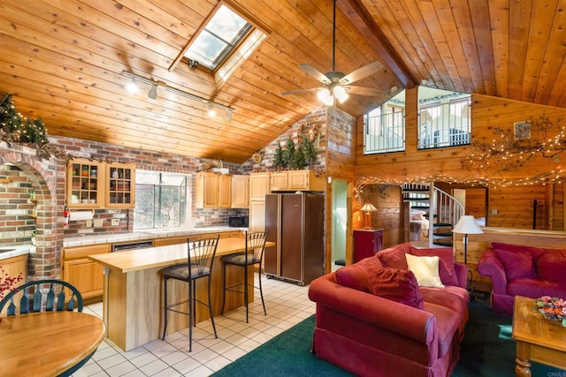 living room featuring lofted ceiling with skylight, light tile patterned floors, and wood ceiling