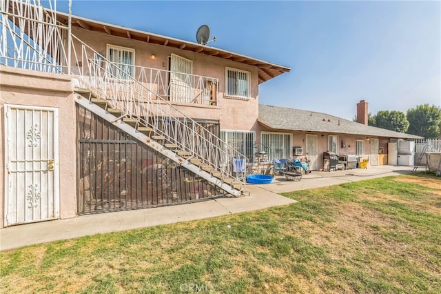 rear view of house featuring a patio and a yard