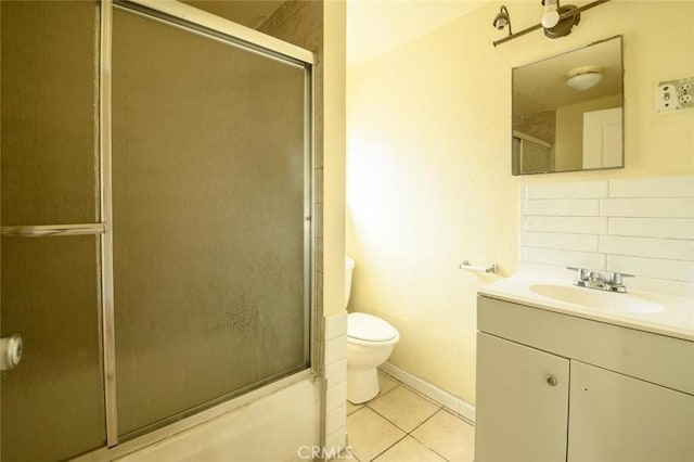 bathroom featuring baseboards, toilet, vanity, decorative backsplash, and tile patterned flooring
