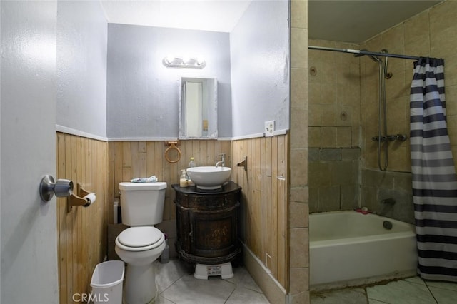 full bathroom featuring wood walls, toilet, shower / bath combo with shower curtain, tile patterned floors, and vanity