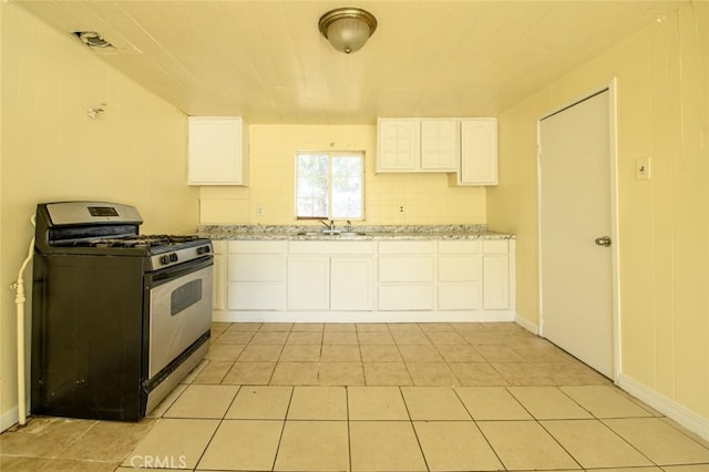 kitchen with black gas stove, sink, decorative backsplash, light stone countertops, and white cabinets