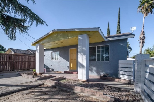 view of front of home featuring stucco siding and fence