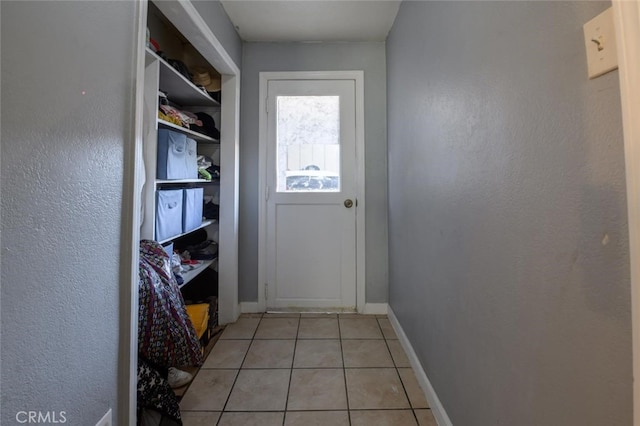 doorway to outside with light tile patterned floors