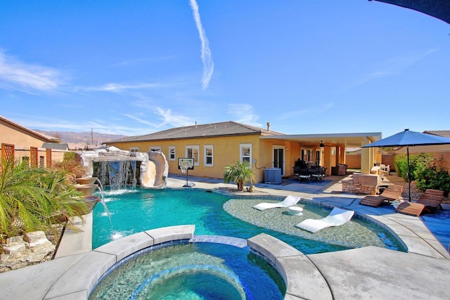 view of swimming pool featuring outdoor lounge area, pool water feature, ceiling fan, an in ground hot tub, and a patio area