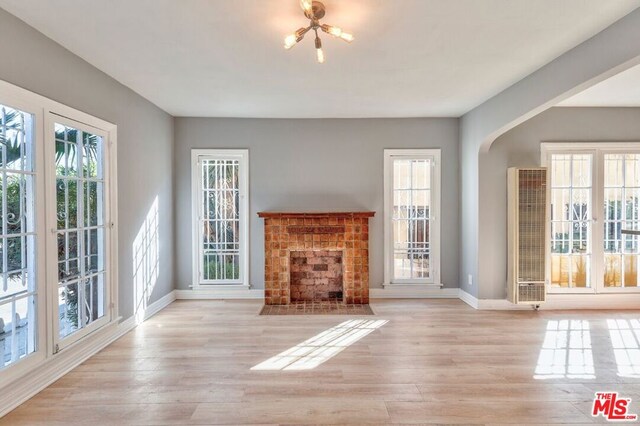 unfurnished living room with light hardwood / wood-style flooring and a wealth of natural light