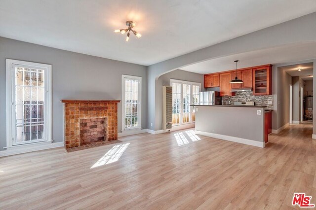 unfurnished living room with light hardwood / wood-style floors and a tile fireplace