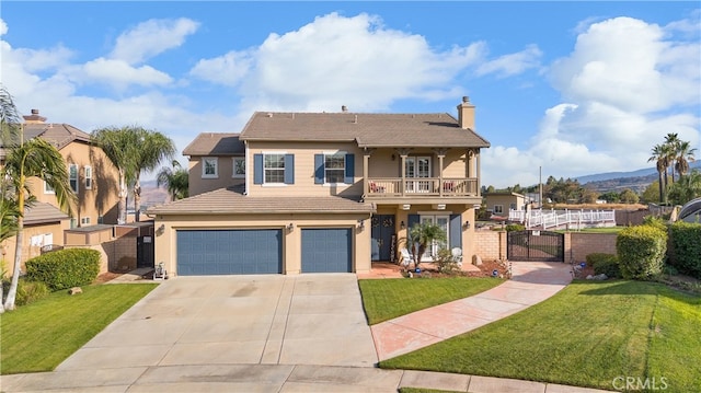 view of front of house featuring a garage, a balcony, and a front yard