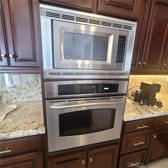 3887 Via Zumaya St, Corona, CA 92881 - kitchen featuring stainless steel appliances, backsplash, dark brown cabinets, and light stone countertops