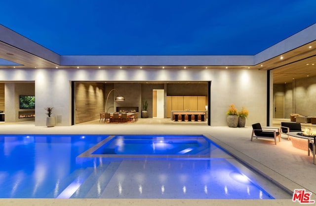 pool at night with a patio area