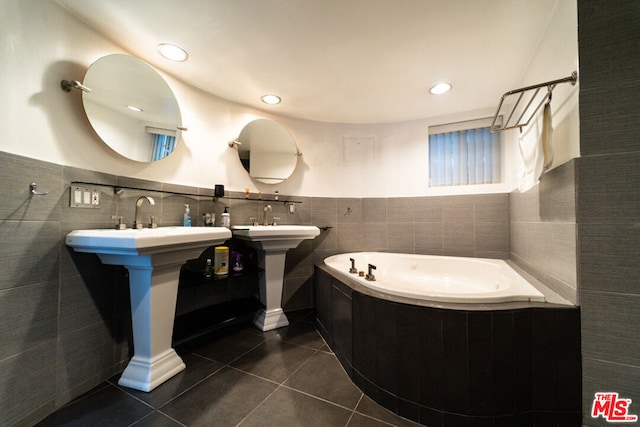 bathroom featuring a tub to relax in, tile patterned flooring, and tile walls