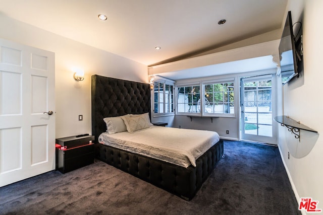 carpeted bedroom with vaulted ceiling and access to outside