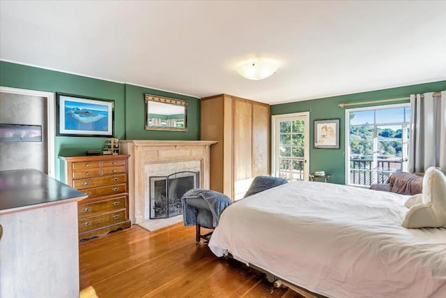 bedroom with hardwood / wood-style floors and access to exterior