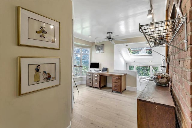 home office featuring a skylight, light hardwood / wood-style flooring, and ceiling fan