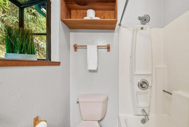 bathroom featuring washtub / shower combination and toilet