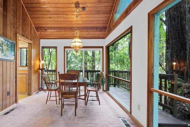 sunroom / solarium with lofted ceiling, wood ceiling, and a chandelier