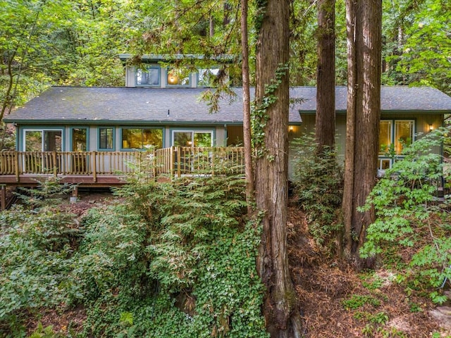 rear view of property featuring a wooden deck