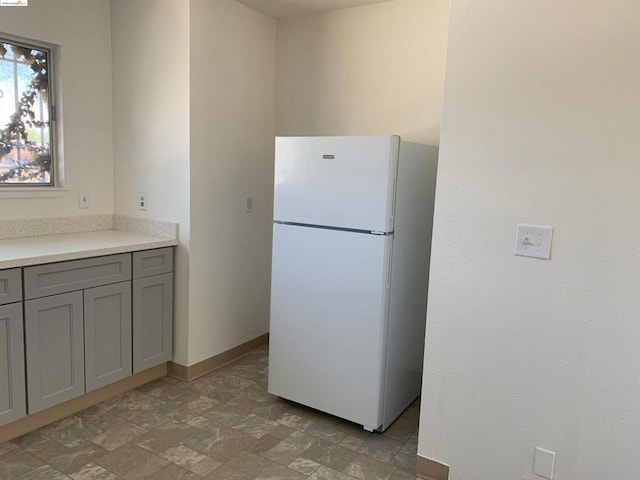 kitchen with white fridge and gray cabinetry