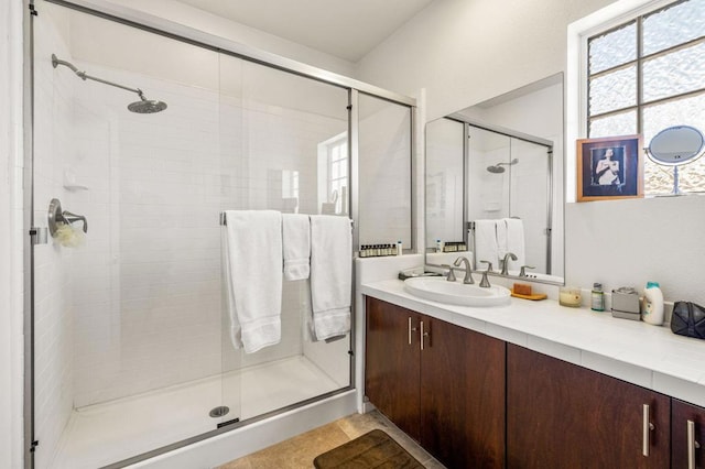 bathroom featuring tile patterned floors, vanity, and a shower with shower door