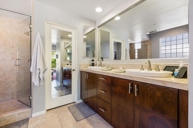 bathroom with tile patterned floors, vanity, and a shower with door