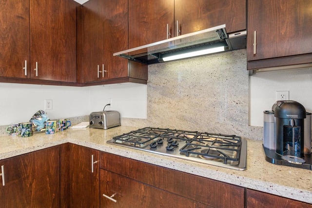 kitchen featuring light stone countertops, tasteful backsplash, and stainless steel gas cooktop