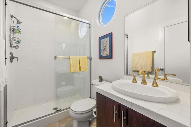 bathroom featuring vanity, toilet, and a shower with shower door