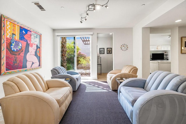 sitting room with ceiling fan and light colored carpet