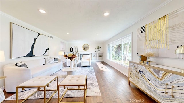 living room with wood-type flooring and ornamental molding