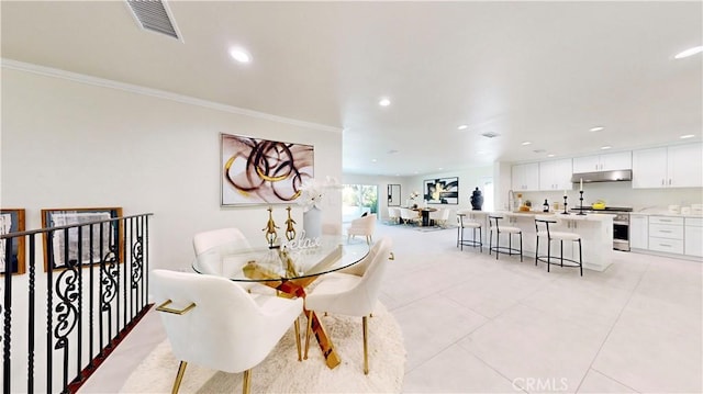 tiled dining area with sink and ornamental molding