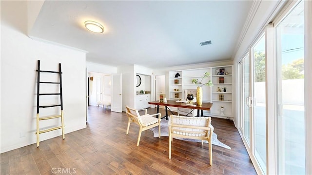 dining area featuring ornamental molding and dark wood-type flooring