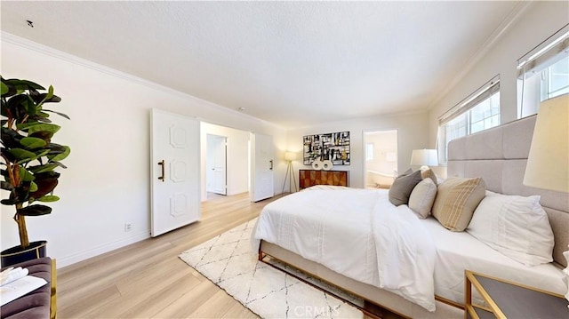 bedroom with ornamental molding, connected bathroom, and light hardwood / wood-style flooring