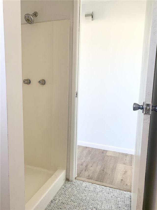 bathroom with a shower and hardwood / wood-style flooring