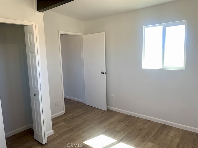 unfurnished bedroom with a closet and dark hardwood / wood-style flooring