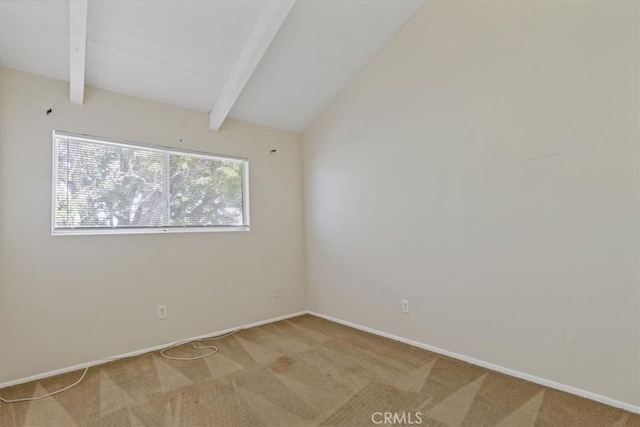 spare room featuring carpet floors and vaulted ceiling with beams