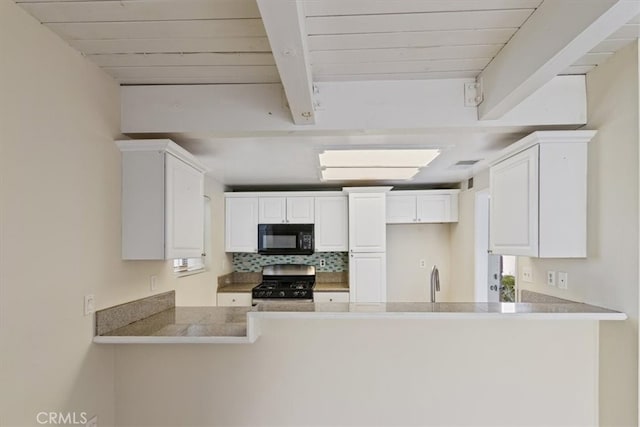 kitchen featuring gas range, sink, kitchen peninsula, backsplash, and white cabinetry