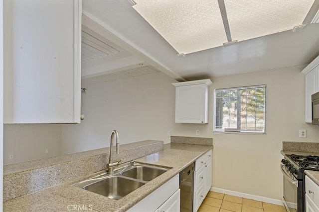 kitchen with light tile patterned flooring, appliances with stainless steel finishes, sink, and white cabinetry