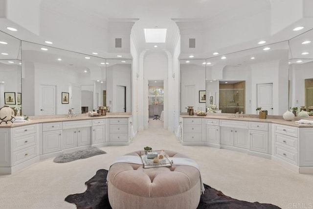 bathroom featuring a high ceiling, crown molding, walk in shower, and vanity