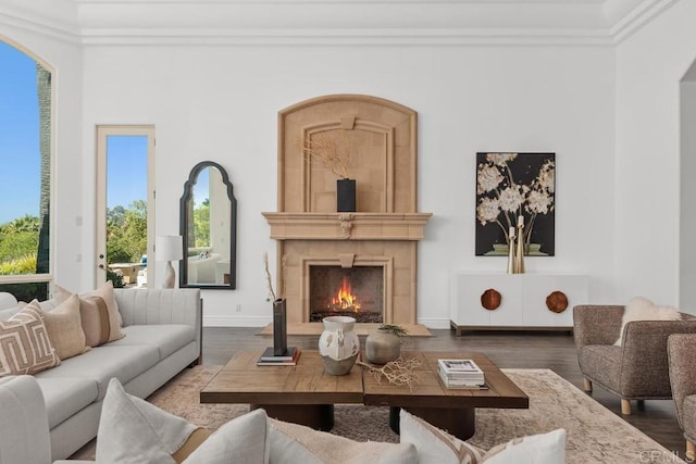 living room with hardwood / wood-style flooring, crown molding, and a tile fireplace