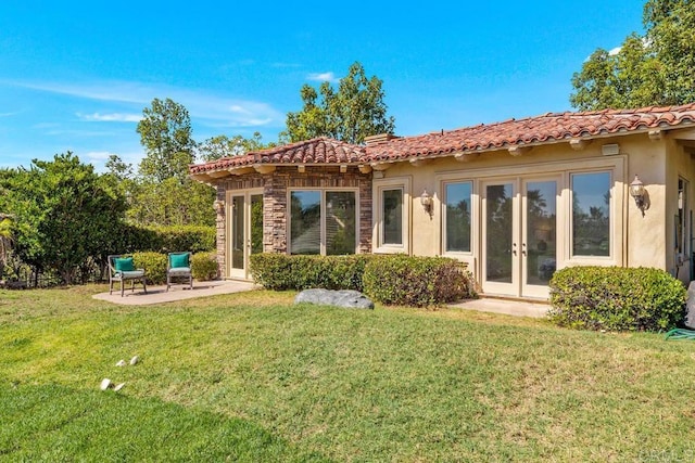 rear view of house featuring french doors, a patio, and a yard