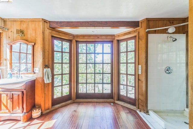 doorway with hardwood / wood-style flooring, plenty of natural light, wood walls, and sink