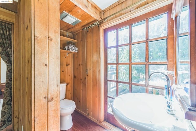 bathroom with toilet, wood ceiling, wood walls, sink, and hardwood / wood-style floors