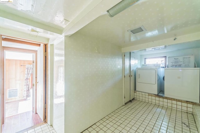 laundry area with separate washer and dryer and light tile patterned floors