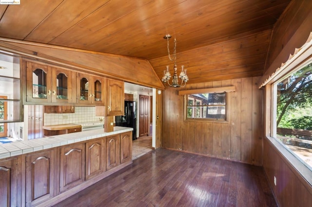 kitchen featuring decorative light fixtures, wooden walls, tile countertops, dark hardwood / wood-style floors, and wooden ceiling