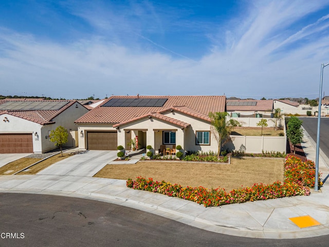 mediterranean / spanish house with a garage, a front lawn, and solar panels