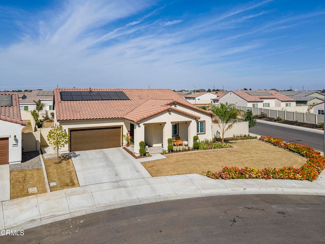 view of front facade featuring solar panels, a front yard, and a garage